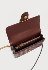 Καπιτονέ μπορντό δερμάτινη τσάντα με χρυσά μεταλλικά στοιχεία, κλείσιμο με κουμπί και ρυθμιζόμενο ιμάντα αλυσίδας. Διαθέτει εσωτερικό φερμουάρ.
