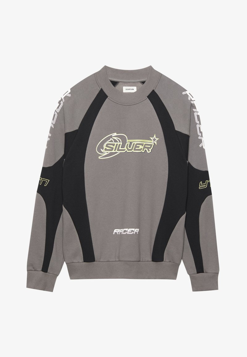 Sweatshirt gris avec des accents noirs, un col rond et des impressions graphiques audacieuses en vert et blanc. Le tissu semble doux avec un design sportif.