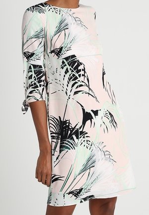 Lichtroze jurk met zwarte en lichtgroene tropische bladpatronen, met driekwartmouwen en gestrikte manchetten.