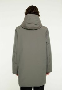 Lång, huva kappa i dämpad grå färg, gjord av slät, hållbar tyg. Har rak skärning och minimalistisk design utan synliga dekorationer.