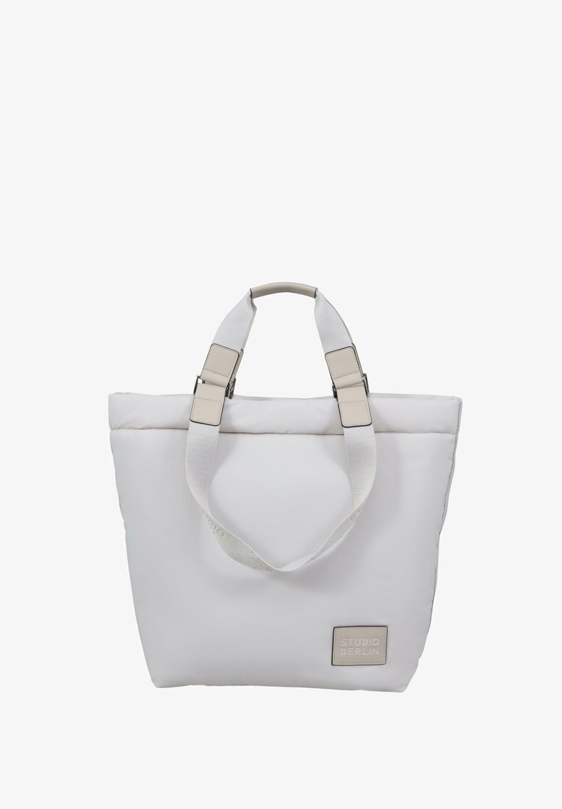 Balta tote krepšys, pagamintas iš paminkštintos medžiagos. Yra du trumpi rankenėlės ir béžinė logo etikete, minimalistinės stačiakampio formos.