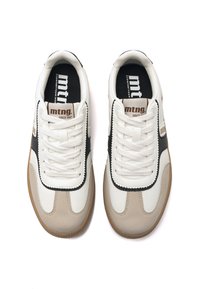 Zapatillas en cuero blanco, negro y beige con suela de goma. Las características incluyen cordones, franjas contrastantes y un logo en la lengüeta.