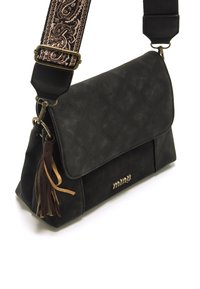 Borsa a tracolla in pelle nera con design trapuntato, una frangia decorativa e una tracolla regolabile con motivo. Presenta accessori in metallo color oro.