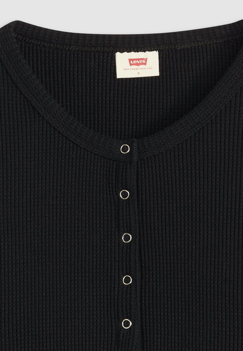 Sort ribbet cardigan med rund hals og fem trykknapper i sølvfarve. Mærket siger "Levi's, San Francisco, Cal, S."