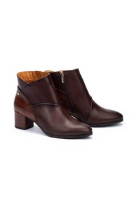 Bottines en cuir marron avec un motif crocodile texturé sur le talon, une fermeture éclair sur le côté et un talon bloc empilé.