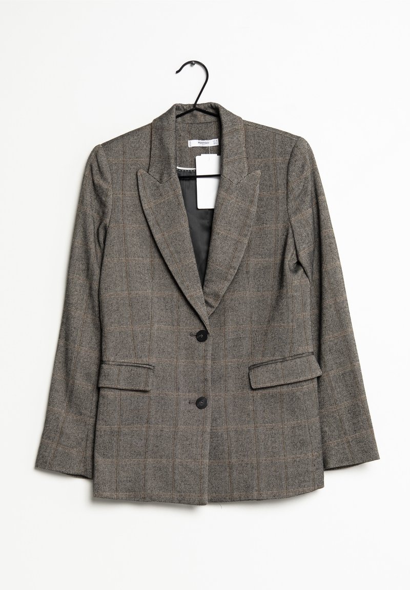 Blazer gris à carreaux avec deux boutons, col à revers et poches à rabat accroché à un cintre noir sur fond blanc.