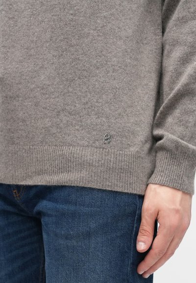 Hall halli kampsun soonikkoes varrukate ja äärega, allosas väike logo, kombineeritud tumeliste siniste teksadega.