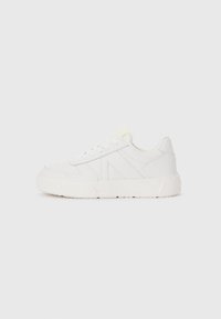 White sneakers with a textured leather upper, featuring a thick rubber sole and lace-up design. Side has a geometric accent detail.