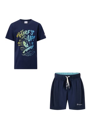 Ensemble pour enfants bleu marine comprenant un t-shirt graphique avec un requin surfeur et un short de bain assorti avec un cordon blanc.