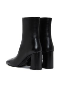 Botas de cuero negras hasta el tobillo con un diseño elegante, puntera afilada y tacón grueso. Textura suave y estética minimalista.