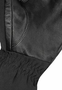 Black leather glove featuring a textured finish, elasticized fabric cuff, and contrasting stitching for a secure fit.