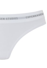 White cotton thong with a smooth texture, featuring a gray elastic waistband labeled "COPENHAGEN STUDIOS." Minimalist design, no additional patterns.