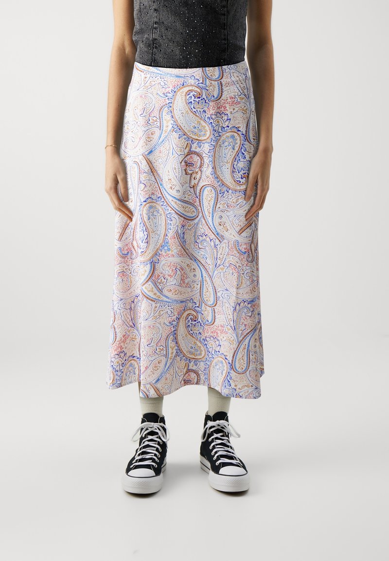 Jupe longue et légère avec un motif paisley coloré aux teintes pastel. Le tissu présente une texture lisse, complétée par des baskets montantes noires.