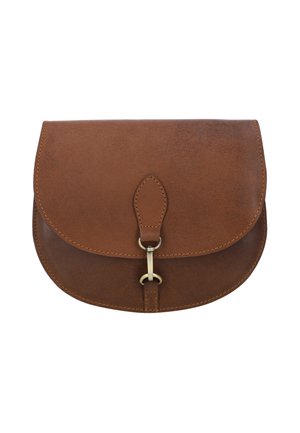 Kvinde iført hvid t-shirt og beige plisseret nederdel holder brun lædertaske med metal spænde foran sig.