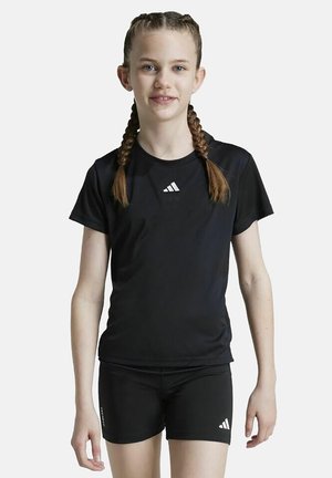 Camiseta atlética negra de manga corta y cuello redondo, con un logo blanco de Adidas. Combinada con pantalones cortos negros.