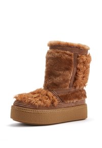 Hnedé čižmy s kožušinovým lemovaním a hrubou platformou, s textúrovanými panelmi a zaobleným tvarom. Mäkký materiál a kontrastné švy.