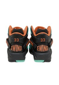 Zapatillas deportivas negras con un forro naranja, que presentan acentos turquesa, correas ajustables y el logo "EWING 33" en el talón.