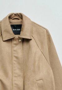 Chaqueta de ante beige con cuello puntiagudo, cierre de botones a presión y bolsillo delantero de ojal, con etiqueta "Salsa Jeans" en el interior.