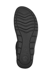 Černá gumová podešev s texturovaným vzorem a vlnitým designem. Obsahuje kruhové logo a číselné značení velikosti, měřící 37.