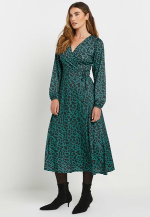 Robe portefeuille à manches longues en vert canard avec un imprimé léopard noir. Elle présente un décolleté en V, un détail froncé à la taille et une jupe fluide.