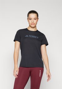 Must mustaheline särk "TERREX" tumehallis värvuses. Kerge kangas, ümmarguse kaelusega disain. Kandmine burgundia värvi retuusidega, millel on logo detail.