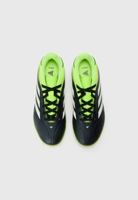 Zwarte en neon groene voetbalschoenen met een slank ontwerp, voorzien van witte strepen, zwarte veters en een gestructureerd oppervlak voor grip.