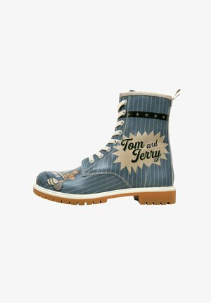 Blue leather combat boot with white stripes, featuring Tom and Jerry graphics, white laces, and a tan rubber sole. Accented with a black banner.