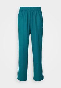 Teal sportbyxor med elastisk midja, sidostreck och avslappnad passform. Mjuk tyg med en slät yta, lämplig för aktivt slitage.