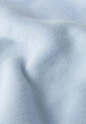 Hellblauer Stoff mit feiner Strickstruktur, dargestellt in weichen Falten und mit leichtem Schattenwurf.