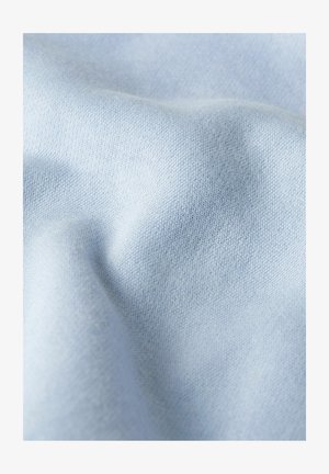 Light blue fabric with fine knit texture, shown in soft folds and slight shadowing.