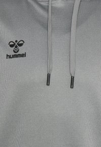 Grijze hoodie van gestructureerde stof, met een zwart Hummel-logo en een koord met zwarte aglets.