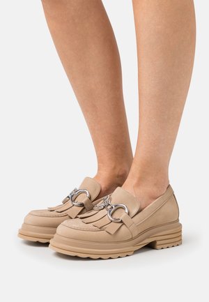 Beige leren loafers met een franjesdetail en accenten van zilver hardware, met een stevige, gestructureerde zool voor extra grip.