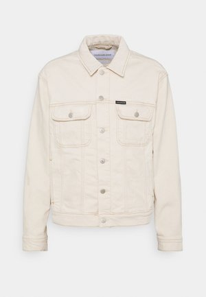 Veste en denim couleur crème avec fermeture à boutons, deux poches poitrine boutonnées et étiquette logo Calvin Klein sur la poche gauche.
