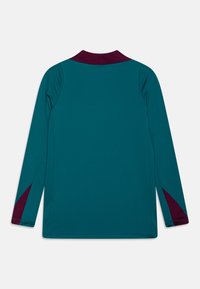 Pitkähihaisen teepparin teal -väri, jossa on marooni kaulus ja sivuakkentit. Kankaan sileä pinta ja kapea malli ilman graafisia yksityiskohtia.