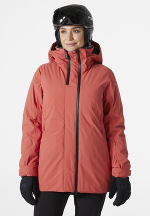 Orange insulated ski jacket with a high collar, front zipper, and adjustable hood. Paired with black gloves for warmth.