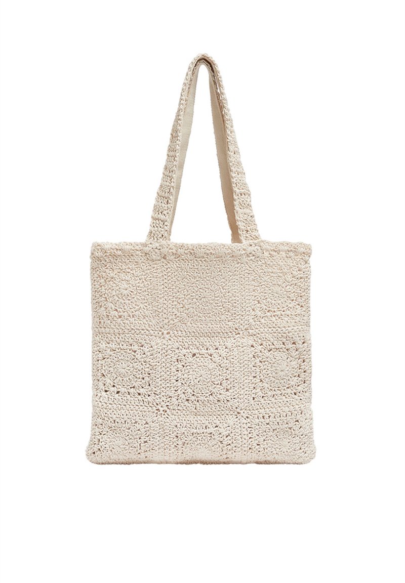 Sac cabas beige en crochet avec motifs floraux carrés et deux longues anses pour le porter à l'épaule.
