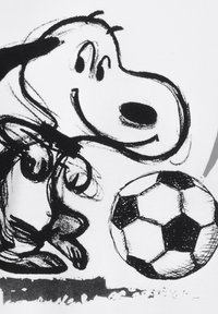 Karikaturhund in Schwarz-Weiß, der mit einem großen runden Kopf lächelt und bereit ist, einen klassischen Schwarz-Weiß-Fußball in der Nähe zu schießen.