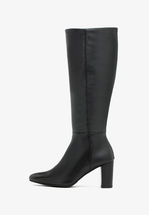 Czarny, sięgający do kolana kozaki wykonane z gładkiej skóry, z ostro zakończonym noskiem i masywnym obcasem. Po bokach przeszycia dodają dodatkowego wzoru.