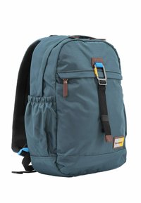 Mochila azul oscuro hecha de un tejido duradero, que cuenta con un bolsillo frontal con cremallera, correas ajustables, acentos marrones y bolsillos de malla laterales.