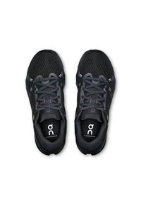 Baskets de sport noires avec tige en mesh respirant, semelles rembourrées et accents réfléchissants. Les caractéristiques comprennent des lacets et un logo sur les semelles intérieures.