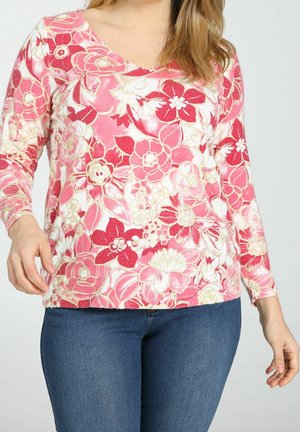 Blusa de manga larga floral con tonos de rosa y rojo y detalles dorados; diseño de pico; textura suave con corte entallado.