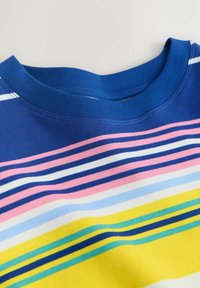 Posnetek iz bližine modre majice z okroglim izrezom in horizontalnimi črtami v roza, beli, modri, rumeni in zeleni barvi po celotnem blagu.