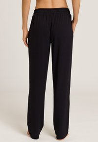 Mustat leveät housut, joissa on joustava vyötärö, valmistettu sileästä kankaasta, rento istuvuus ilman näkyviä kuvioita tai yksityiskohtia.