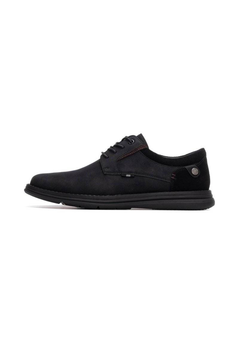 Zapatos negros con cordones, con parte superior de ante y tejido suave, suela de goma plana y un sutil detalle de costura a lo largo del lateral.