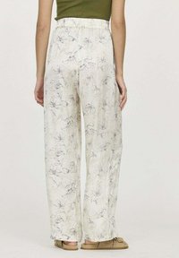 Pantalons légers de couleur crème avec des imprimés floraux, taille élastique, coupe décontractée et jambes droites, fabriqués à partir de tissu doux.