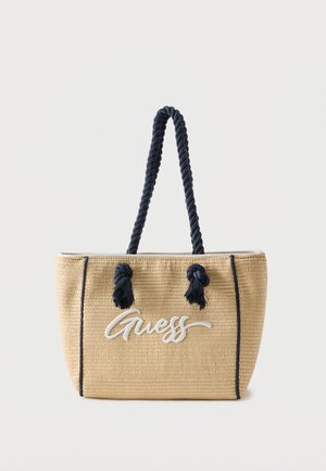 Sac fourre-tout beige tissé avec poignées en corde noire et logo "Guess" brodé sur le devant, avec des détails de passepoil noir sur les bords.
