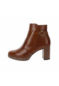 Bottine en cuir marron avec un bout arrondi, une boucle latérale en accent et un talon bloc en bois texturé. Finition lisse, design mi-hauteur.