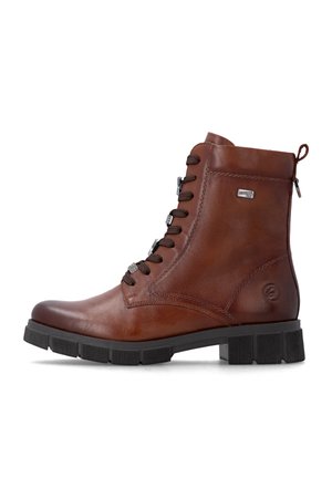 Bottine en cuir marron avec semelle en caoutchouc noir, lacets noirs, fermeture éclair latérale et logo métallique de la marque sur le côté.