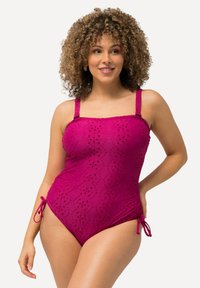 Maillot de bain une pièce en rose framboise avec un tissu à œillets texturé, des bretelles réglables et des liens sur les côtés pour ajuster la taille. Présente un design ajusté.