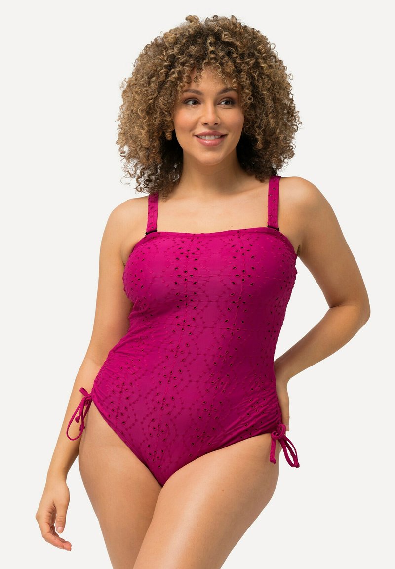 Maillot de bain une pièce en rose framboise avec un tissu à œillets texturé, des bretelles réglables et des liens sur les côtés pour ajuster la taille. Présente un design ajusté.
